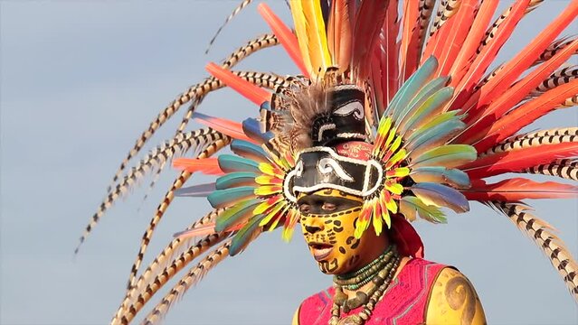 prehispanic indian mexican man dancer with make up and attire of aztec culture with feather plume singing