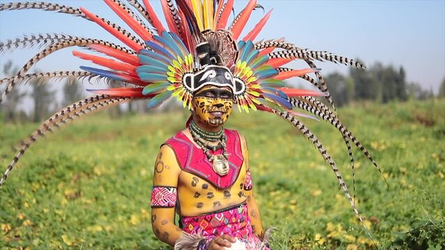 mexican man in prehispanic dancer costume for day of the dead celebration with plume