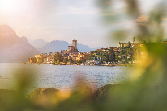 Idyllic coastline in Italy: Blue water and a cute village at lago di garda, Malcesine, sunset