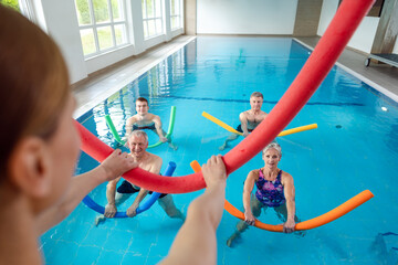 People in aqua fitness class during a physical therapy session in a physiotherapy center - 523397961