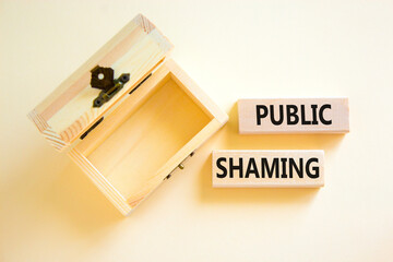 Public shaming symbol. Concept words Public shaming on wooden blocks on a beautiful white table white background. Empty wooden chest. Business and public shaming concept. Copy space.
