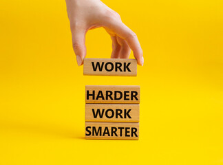 Work harder Work smarter symbol. Wooden blocks with words Work harder Work smarter. Beautiful yellow background. Businessman hand. Business concept. Copy space.