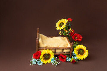 background texture empty space for baby. children's bed for a photo session of newborns. photo props. the bed is decorated with sunflowers and poppies. furniture for dolls . interior in Ukrainian styl
