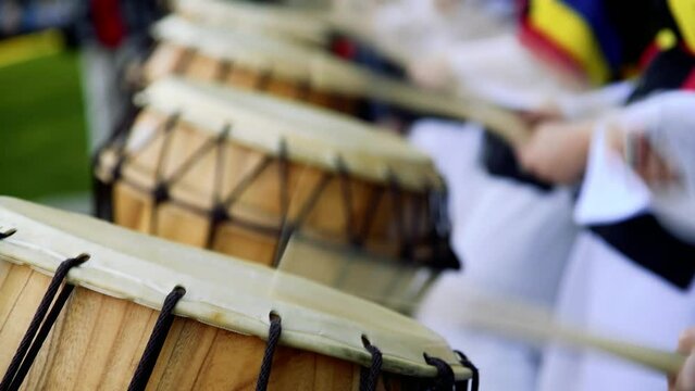 Group of musicians play drums outdoors