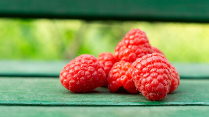 Ripe raspberries on a green background