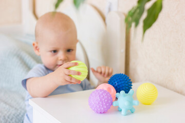 Cute baby boy toddler playing with massage ball.