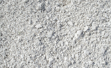 Natural chalk mineral background. Small smooth calcite stones are mixed with chalk clay. Calcium in nature. Natural white chalk texture