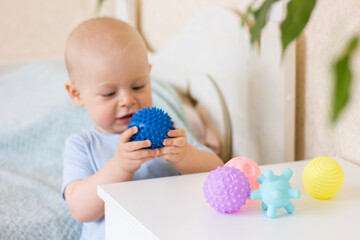Cute baby boy toddler playing with prickly massage ball.