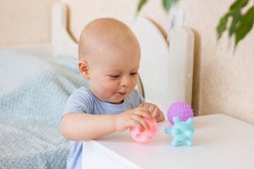 Obraz na płótnie Canvas Cute baby boy toddler playing with massage ball.
