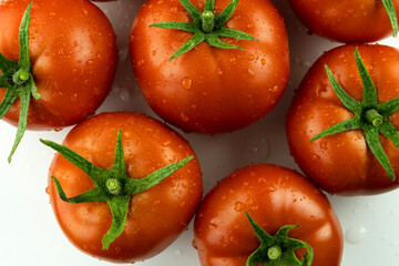 A red tomato highlighted on a white background with an edged leg. Stack of images macro photography with full depth of field.