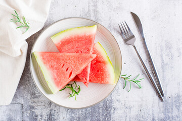Pieces of ripe watermelon on a plate on the table. Summer refreshment. Top view