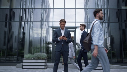 Obraz na płótnie Canvas Confident businessman holding smartphone getting great news. Success concept.