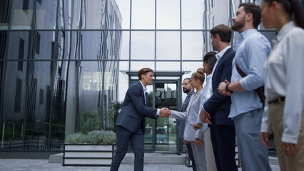 Thankful leader shaking hands at office building. Corporate lifestyle concept.