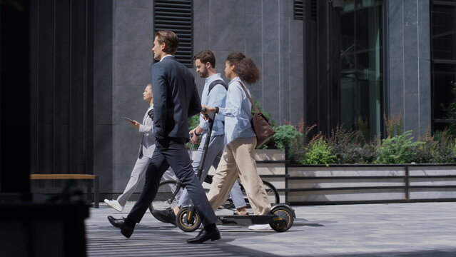 Corporate People Walking Holding Bicycle Kickscooter Downtown. Green Transport.