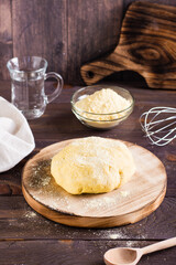 Ready raw dough for baking mexican tortillas on the board. Homemade pastries. Vertical view