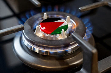A burning gas burner of a home stove, in the middle of which a flag is depicted - Jordan