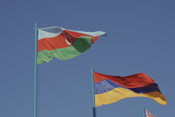 The national flags of Azerbaijan and Armenia are fluttering in the wind.