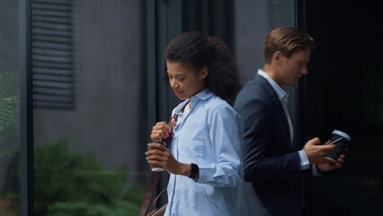 Joyful woman walking coffee cup in hand. Young successful worker enjoy sunny day