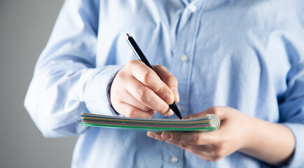 female hand writing on an blank notebook