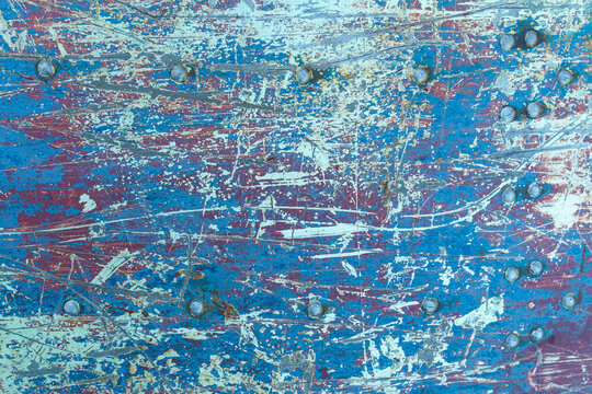 Texture of rusty metal with rivets, blue and red paints. © Dzmitry