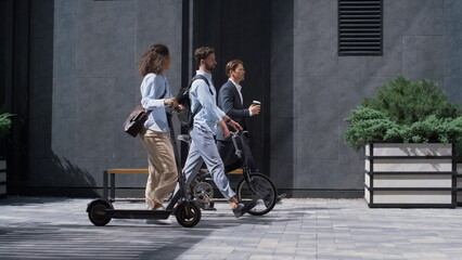 Two colleagues going downtown street talking. Shared eco-friendly transportation