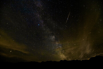 milky way and meteor over mountains by lake Bohinj