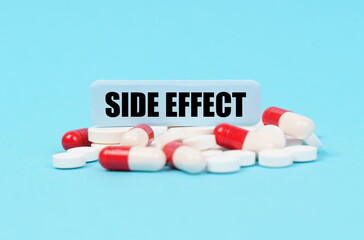 On the blue surface of the pills, capsules and a plate with the inscription - SIDE EFFECT