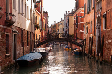 Fototapeta na wymiar The old bridge made with decorated iron on the typical canal in Venice