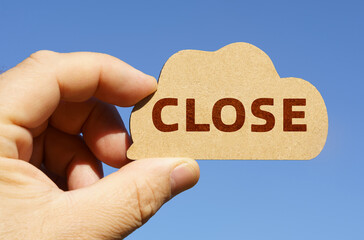 Against the background of the sky in the hands of a man, a figure of a cloud with the inscription - Close