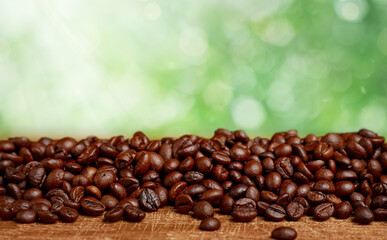 roasted coffee beans against green natural background