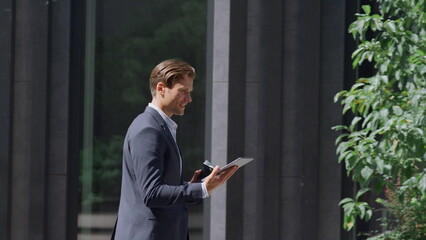 Relaxed finance manager moving playing video games in modern gray workplace yard