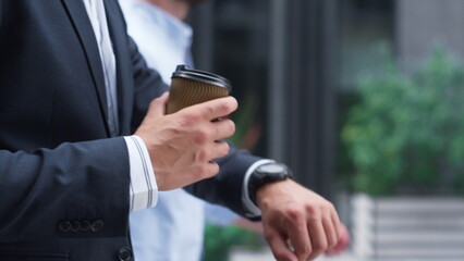 Confident businessman walking hold coffee downtown. Male hand with cup closeup.