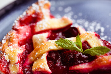 Close up of mint leaf on cherry tart on plate in cafe