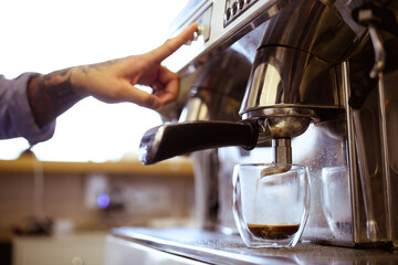 Partial view of barista making coffee with machine in cafe 