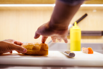 Faceless view of cook pouring olive oil on ciabatta in cafe kitchen  