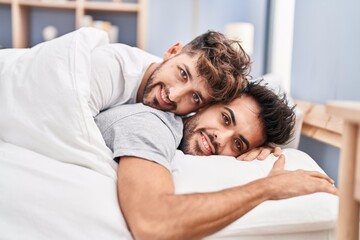 Young couple hugging each other lying on bed at bedrooom