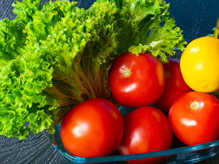 Fresh vegetables. Tomatoes and lettuce. Vegetarian food. Vegetable diet concept. Tomatoes and lemon behind glass container. Fresh vegetables close up. Food products on wooden table. Summer still life
