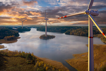 Offshore wind generators. Regenerative energy. Wind turbines rise above river. Several windmills...