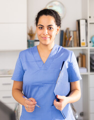 Positive woman is standing with documents in clinic