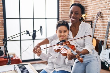 African american mother and son student learning play violin at music studio