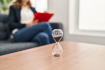 Young woman having psychology session sitting on sofa at clinic