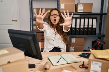 Young hispanic woman working at small business ecommerce doing stop gesture with hands palms, angry and frustration expression