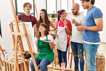 Fototapeta premium Group of young paint students smiling happy and looking draw of partner at art studio.