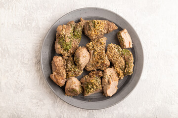 Stewed turkey fillet with garlic on gray concrete background. top view, close up.