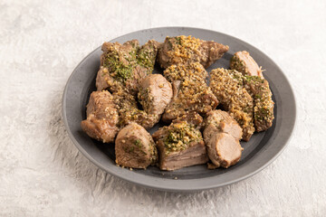 Stewed turkey fillet with garlic on gray concrete background. side view, close up.