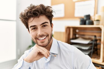 Naklejka premium Young hispanic businessman smiling happy working at the office.