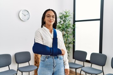 Young african american woman smiling confident injury on arm at clinic waiting room