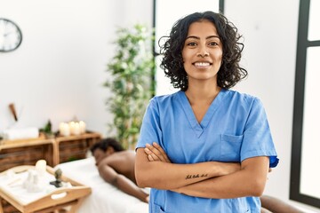 Young physiotherapist woman smiling happy standing with arms crossed gesture. at the clinic....