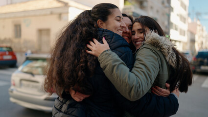 Fototapeta na wymiar Mother and daugthers smiling confident hugging each other at street