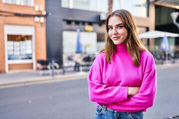 Young woman smiling confident standing with arms crossed gesture at street